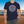 Drink Package Club cruise T-shirt with white circular badge lettering, stars, gold anchors, and colourful cocktail graphics.
