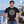 Drink Package Club cruise T-shirt with white circular badge lettering, stars, gold anchors, and colourful cocktail graphics.